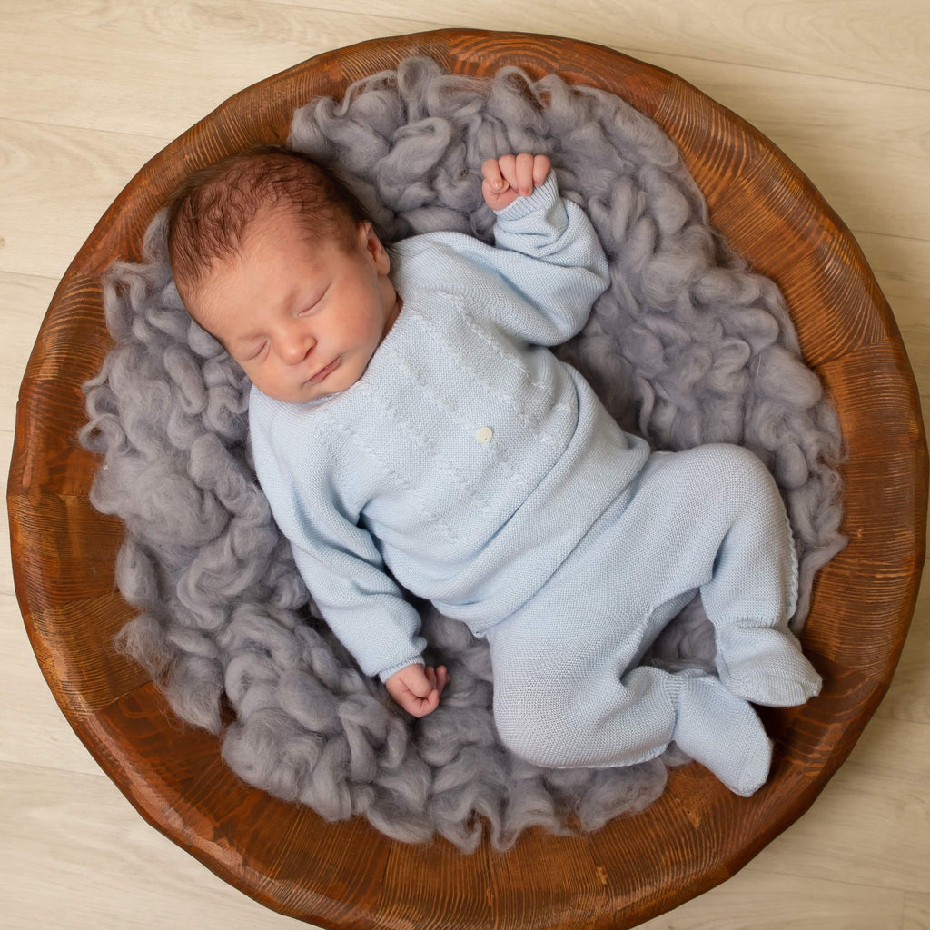 Baby in wooden bowl with grey blanket wearing boys blue knitted detail leggings set