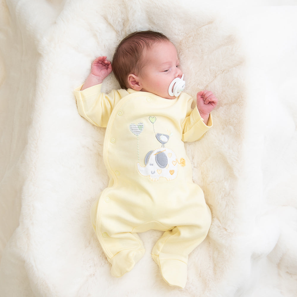 Baby falling asleep wearing 'Elephant & Bird' lemon cotton sleepsuit