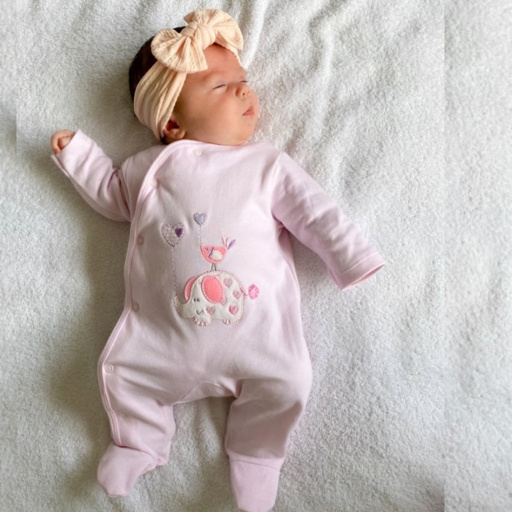 Baby sleeping wearing 'Elephant & Bird' pink cotton sleepsuit