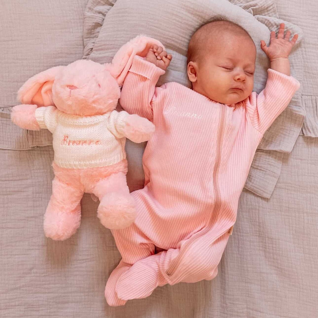 Baby with personalised bunny teddy wearing embroidered personalised pink baby sleepsuit
