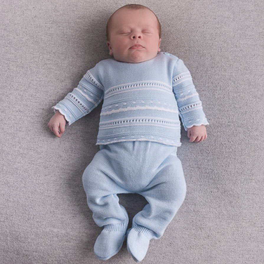Sleeping baby on grey floor wearing blue & white pointelle knitted set