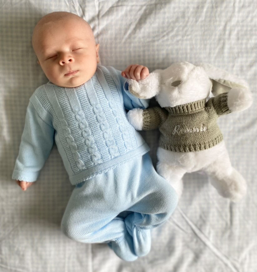 Baby with bunny tedding wearing blue cable knitted set