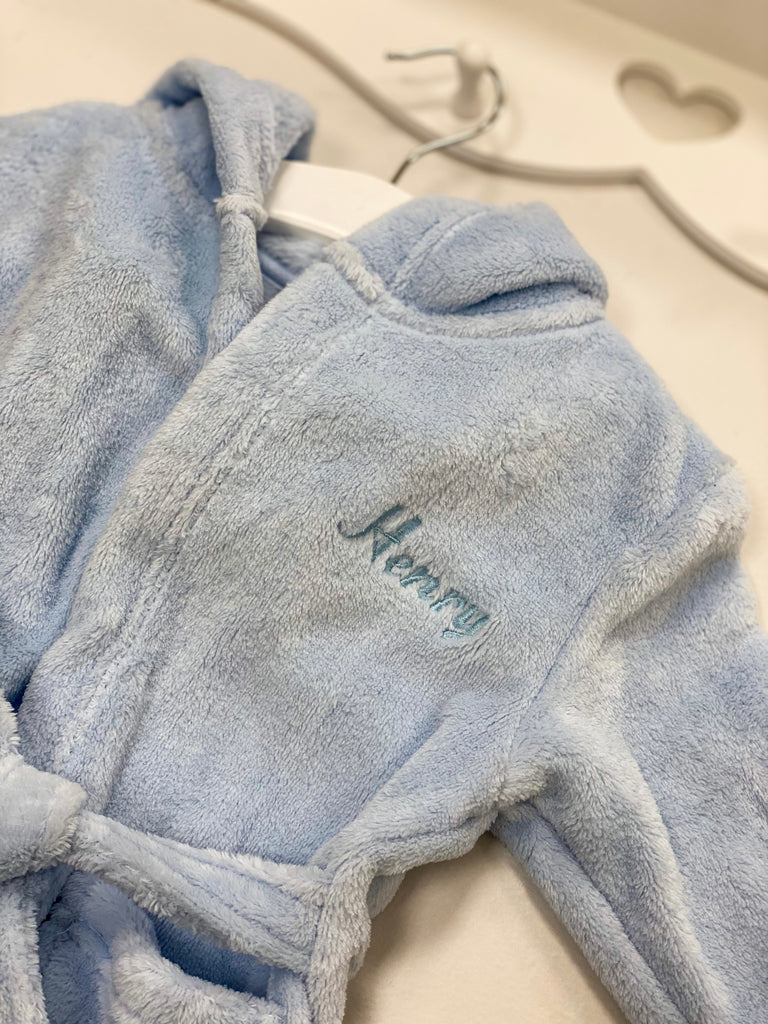 Close up of blue personalised embroidered dressing gown on hanger