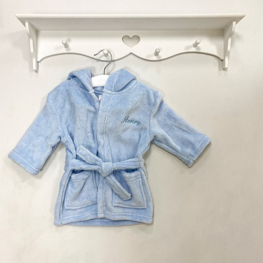 Blue personalised embroidered dressing gown hanging from shelf