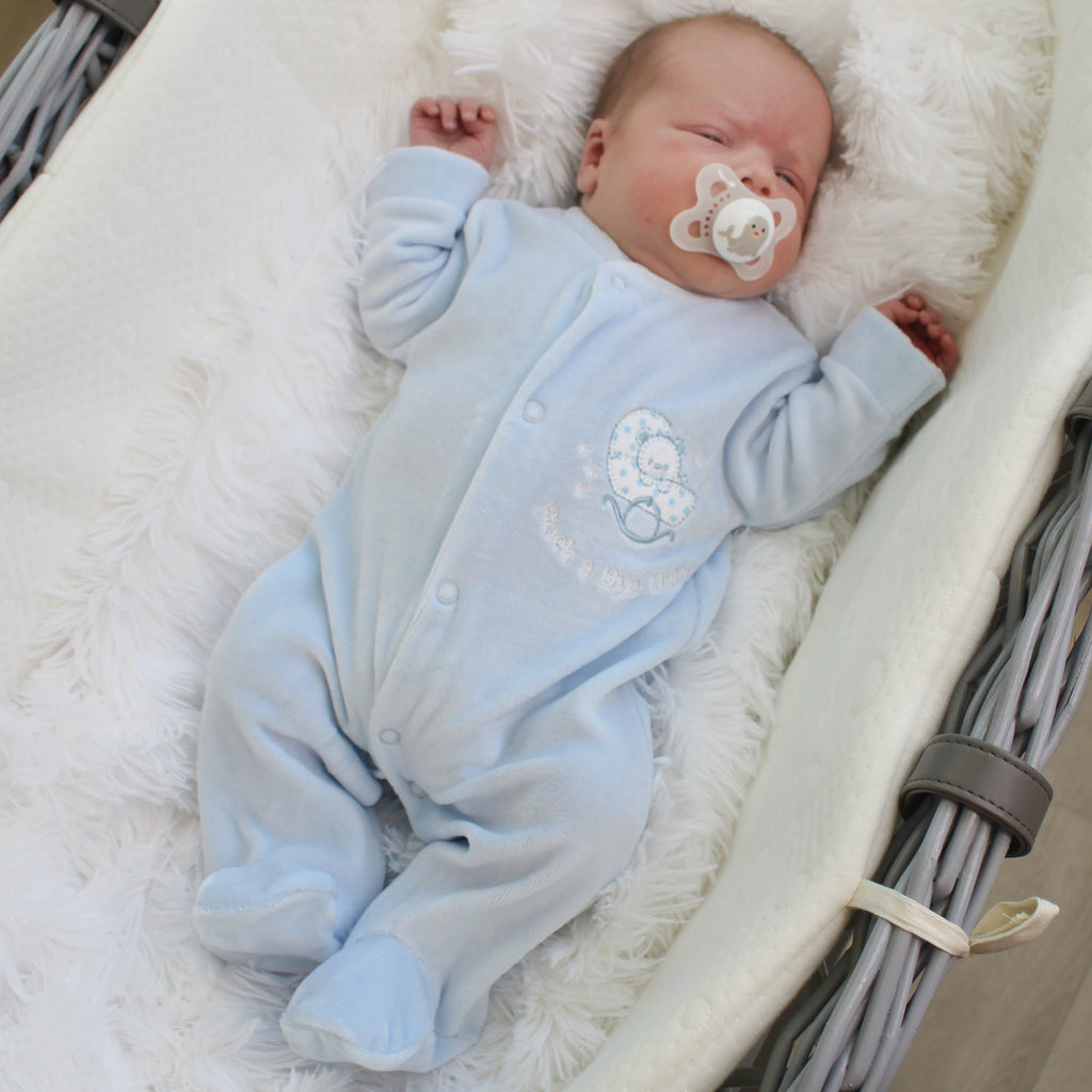 Baby wearing the blue rock-a-bye baby velour sleepsuit
