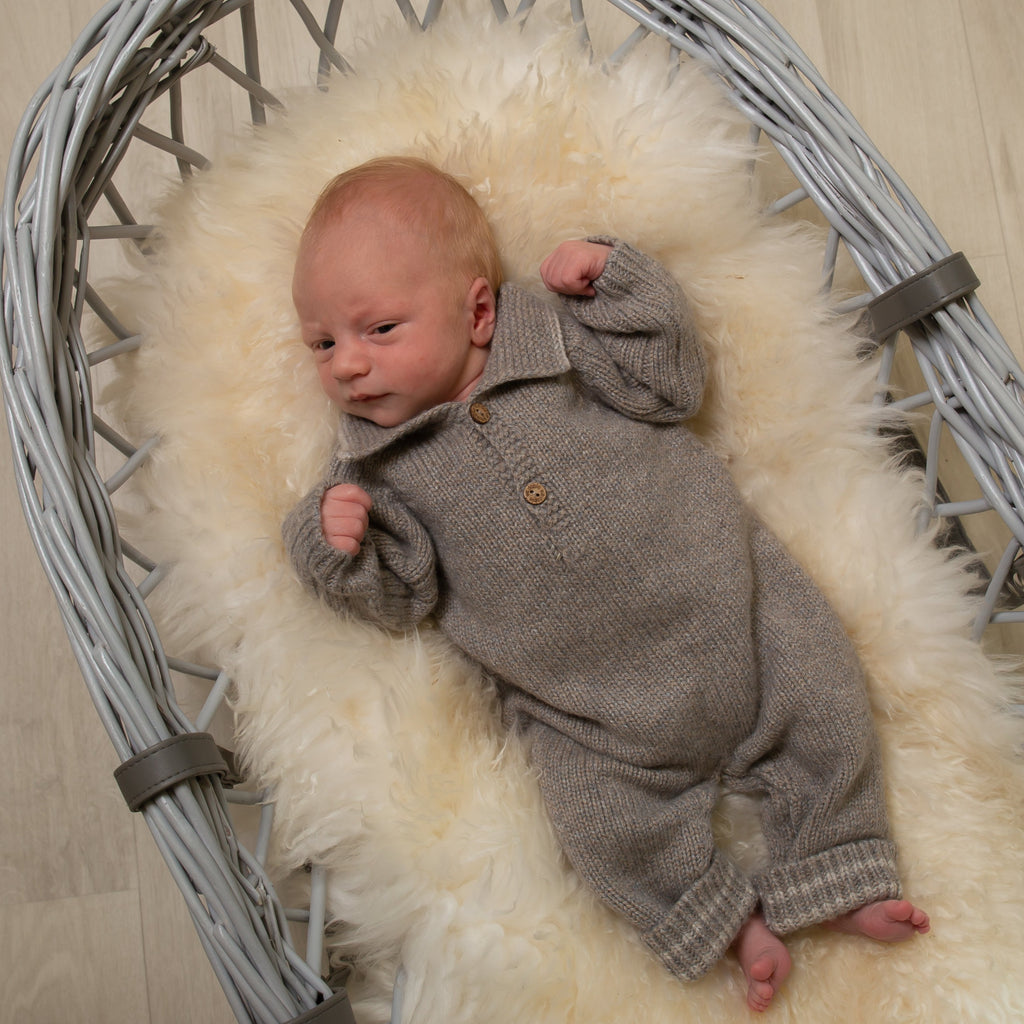 Baby in moses basket wearing boys wool knit polo all in one