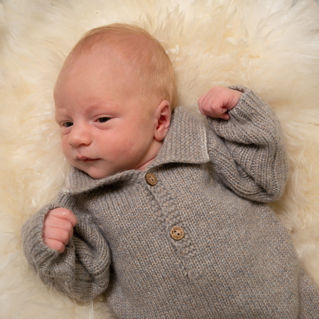Close up of baby wearing boys wool knit polo all in one