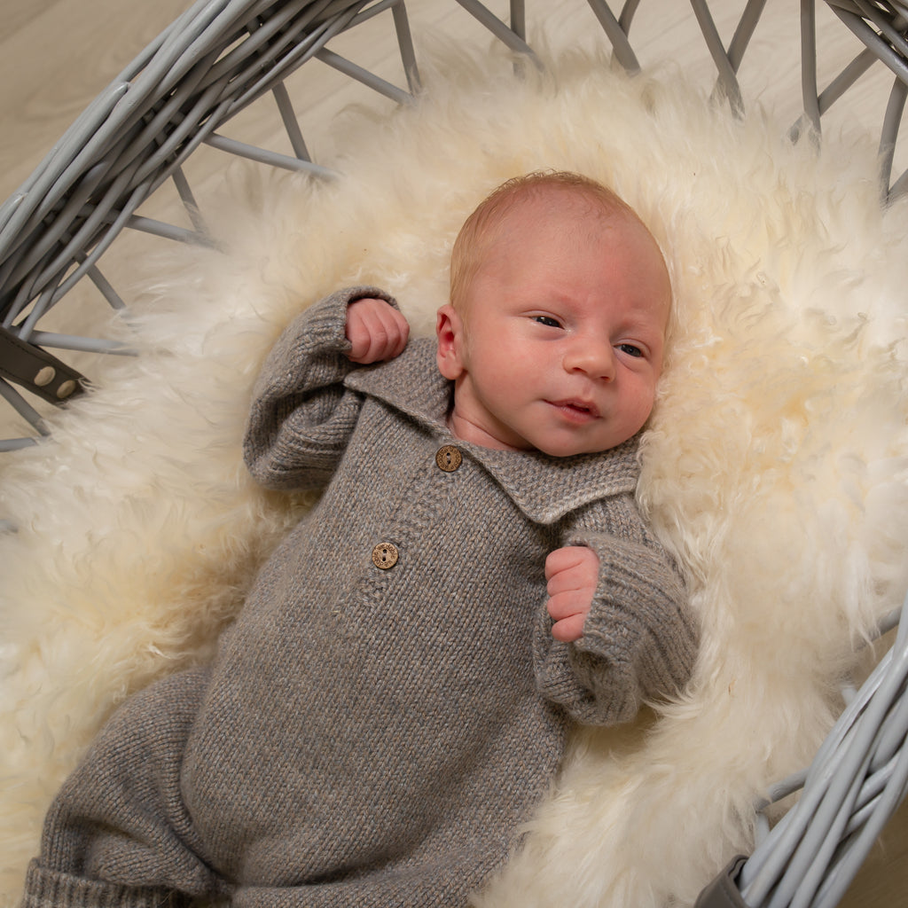 Baby in moses basket on white fur blanket wearing Boys Wool Knit Polo All In One