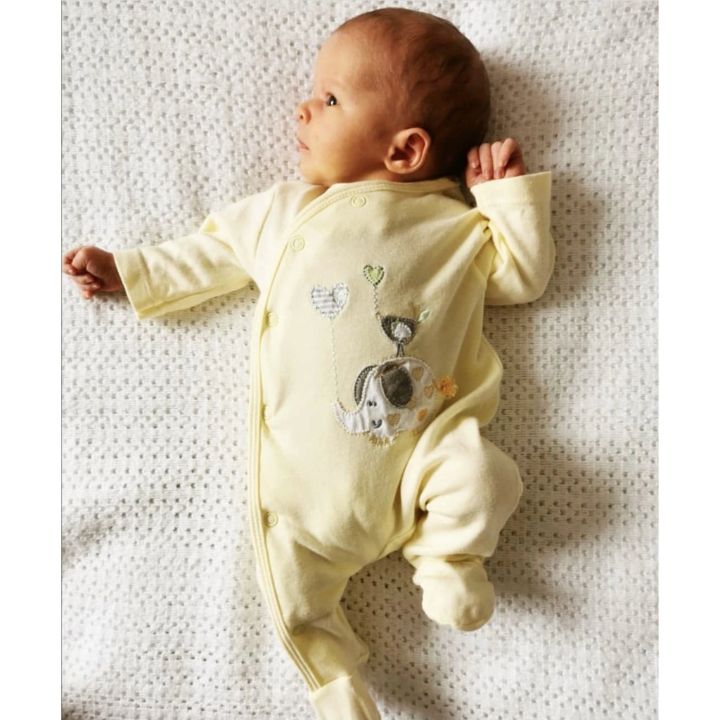 Baby smiling wearing 'Elephant & Bird' lemon cotton sleepsuit
