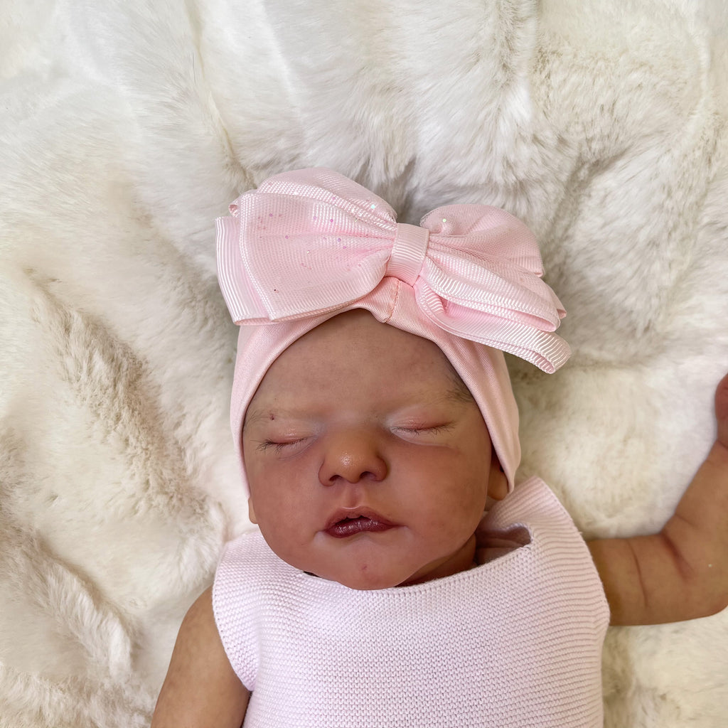 Sleeping baby in the baby pink glitter bow headband
