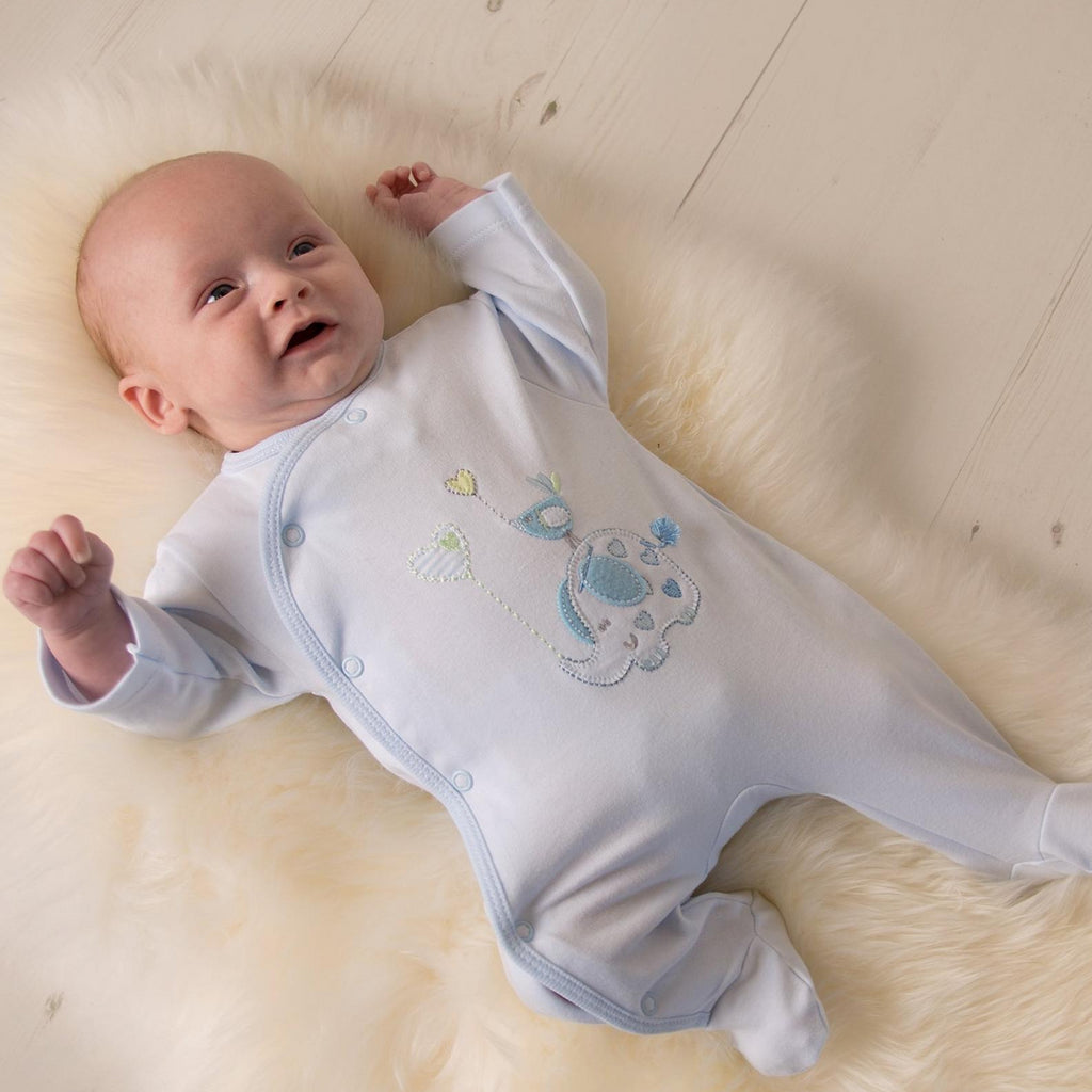 Baby smiling wearing 'Elephant & Bird' blue cotton sleepsuit