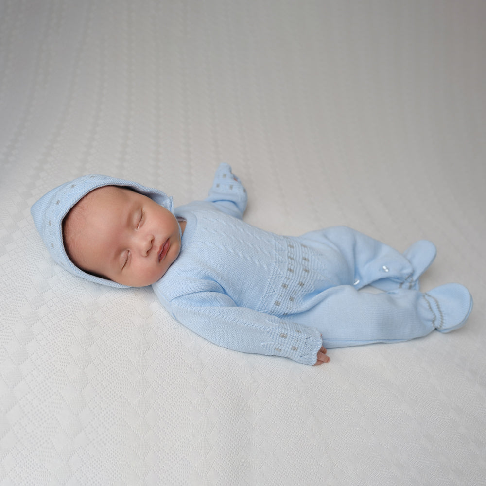 Baby wearing the blue zig zag knitted onesie and hat