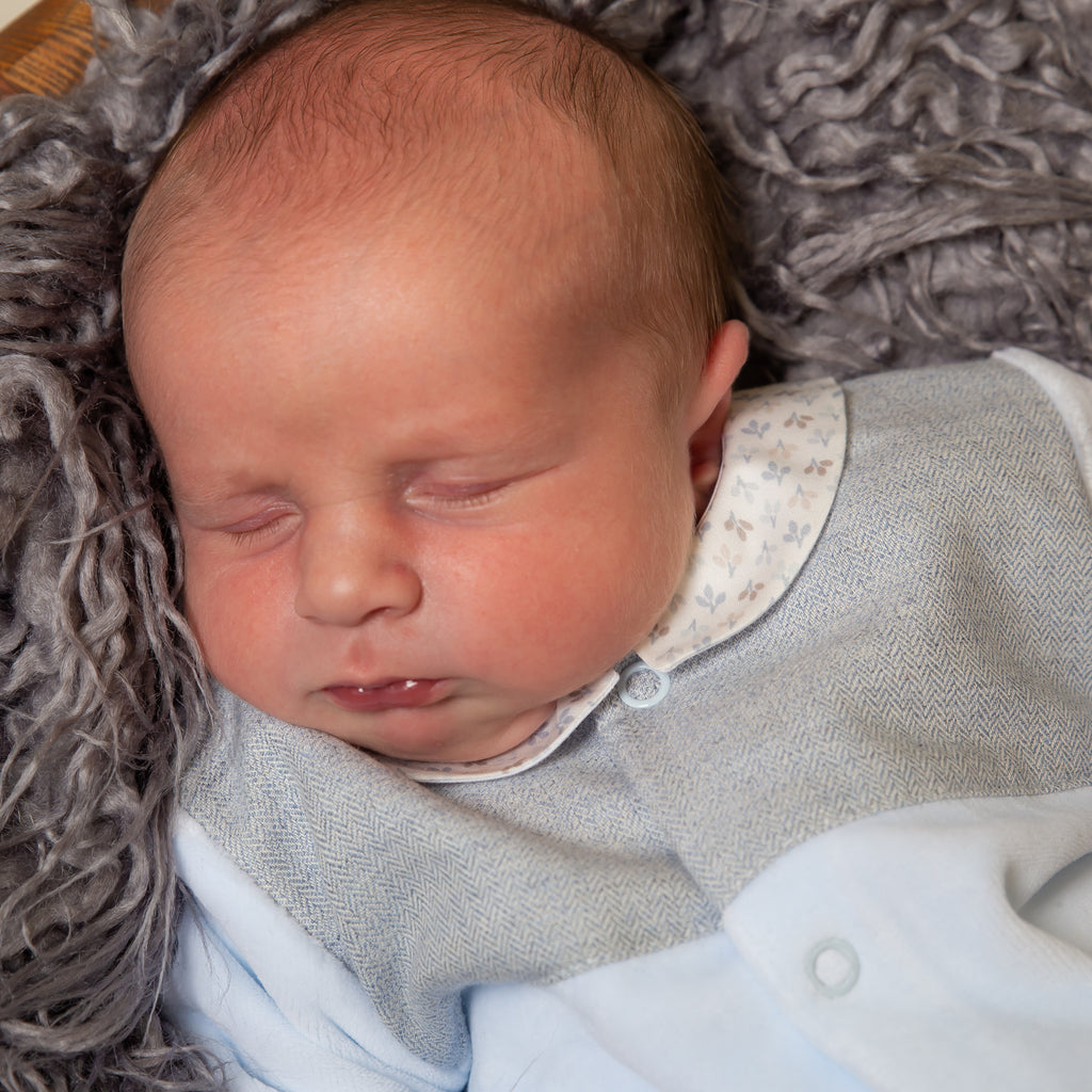 Close up of sleeping baby wearing Blue Velour Tweed Panel Leaf Sleepsuit