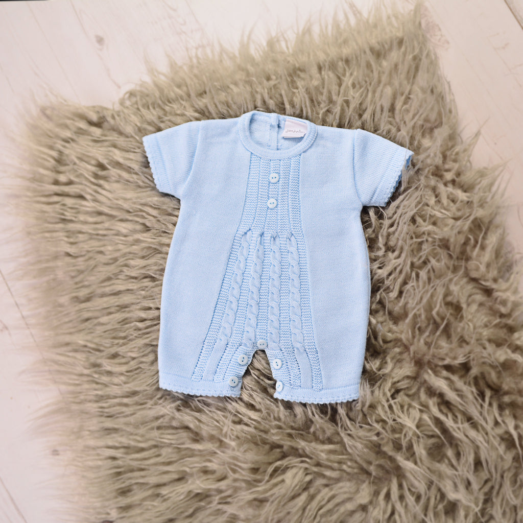 Blue cable knitted romper on brown fur blanket