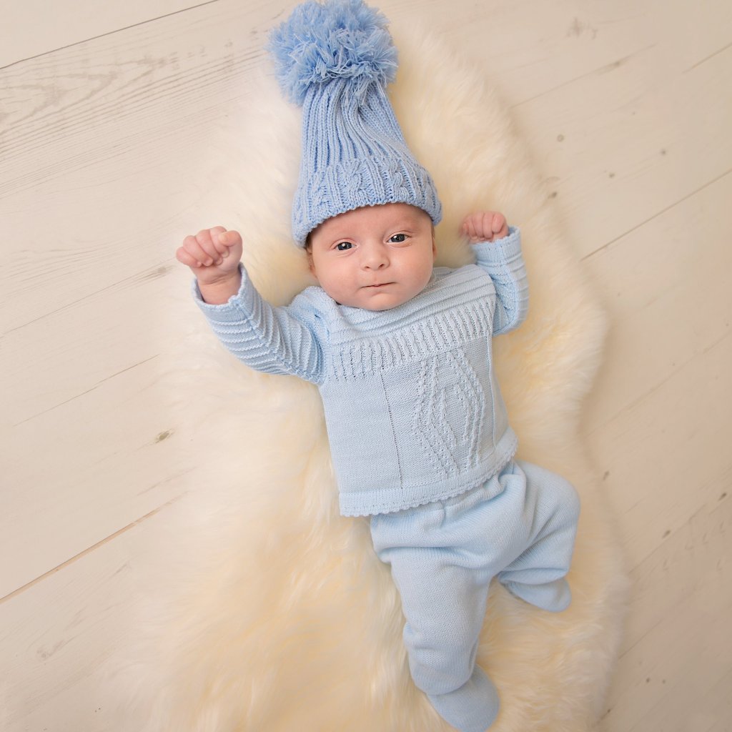 Baby in large knitted hat and blue diamond knitted set
